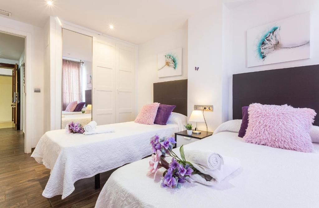 Habitación con 3 camas con flores. en Brisas Playa 3 Baños, en Cádiz