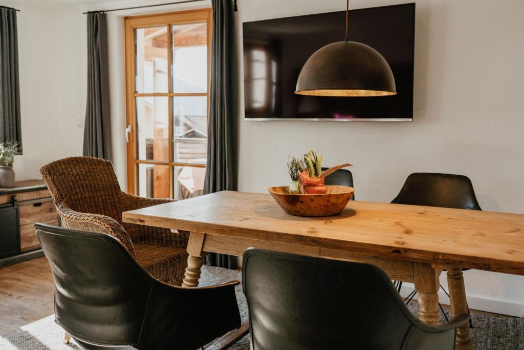 a dining room with a wooden table and chairs at Ferienwohnungen Beargzit in Bad Hindelang