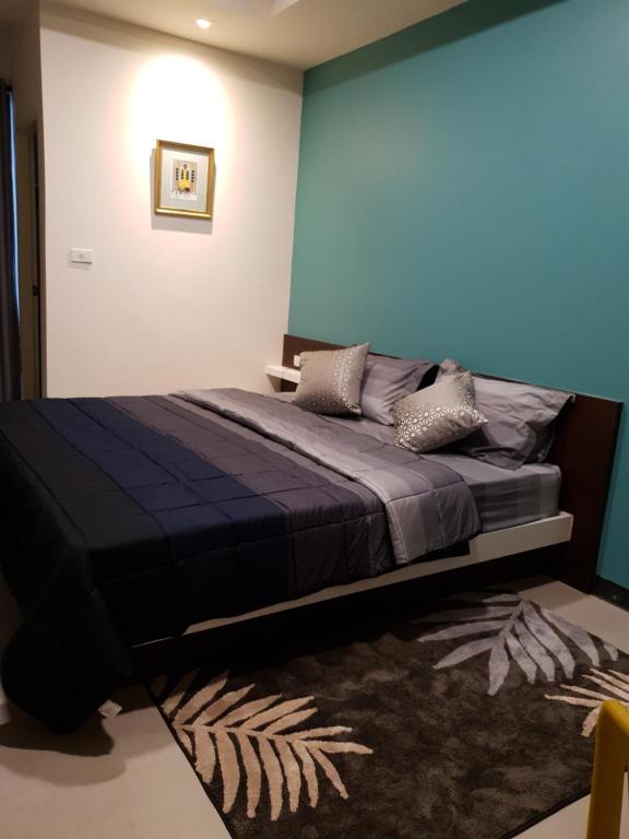 1 dormitorio con 1 cama con pared azul en 552 Residence en Bangkok
