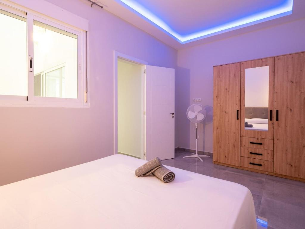 Schlafzimmer mit lila Wänden, einem Bett und einem Fenster in der Unterkunft Luxury Suite Fuengirola 1 in Fuengirola