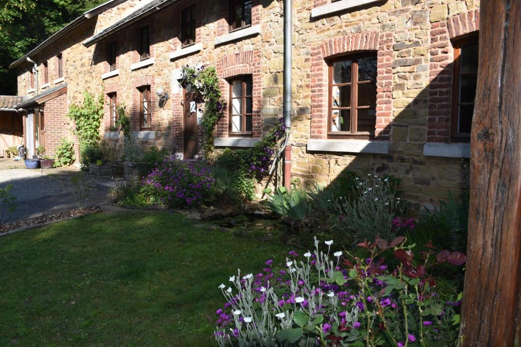 un edificio de ladrillo con un patio con flores en Maison Bod ' Art, en Theux