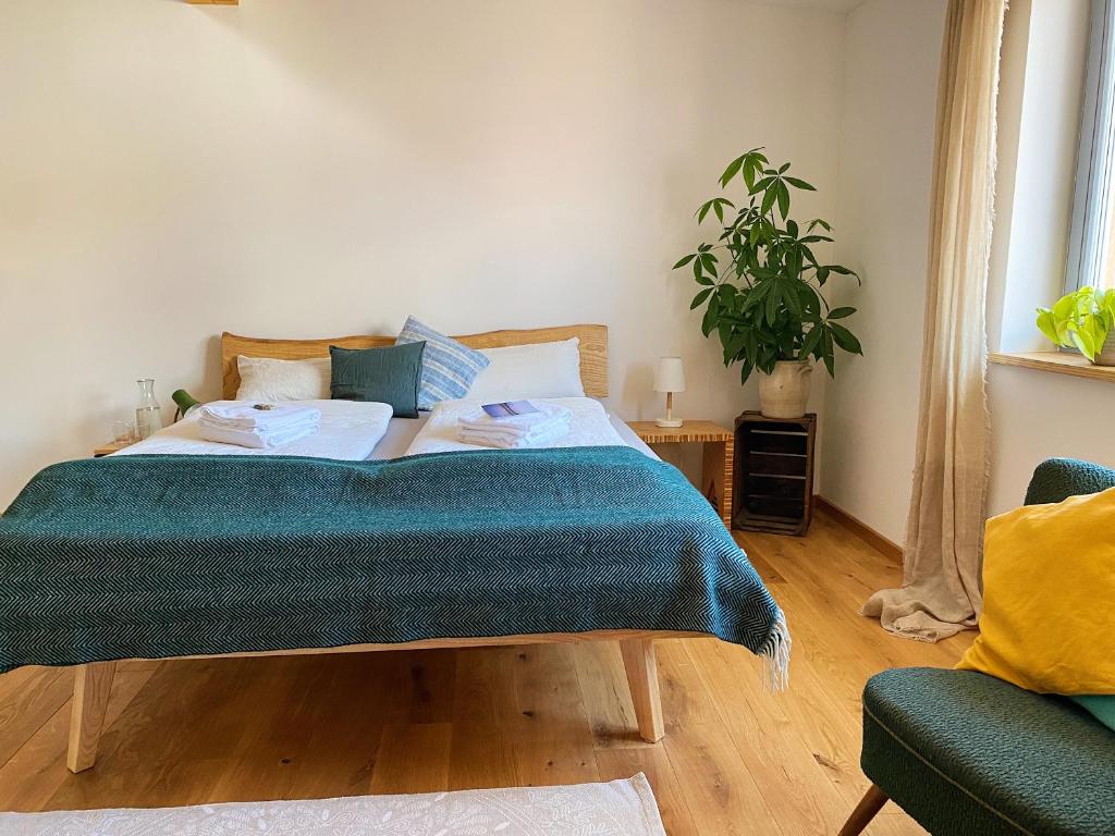Un dormitorio con una cama con una manta verde. en Gasthaus Canow en Wustrow