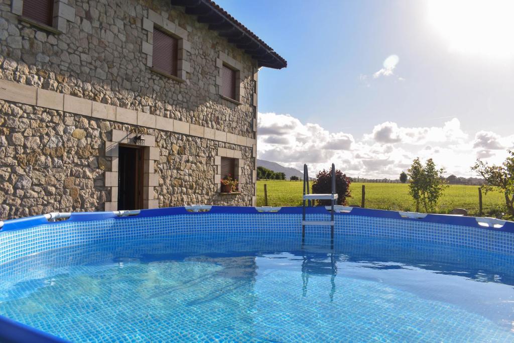 una gran piscina azul junto a un edificio en ¡Nueva! Encantadora casa rústica, cómoda y amplia., en Pontones