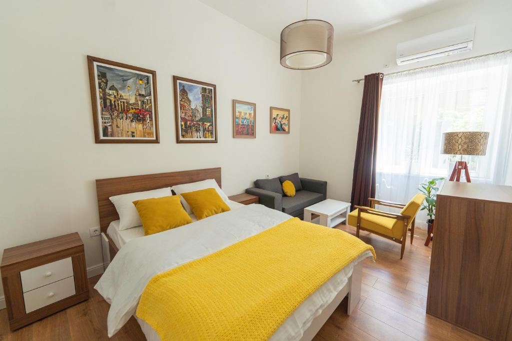 a bedroom with a bed with a yellow blanket at Sleep Hostel in Niš