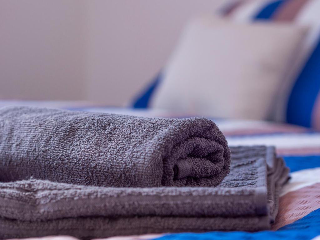 una pila di asciugamani appoggiata sopra un letto di Rekreační dům Olomučany a Olomučany