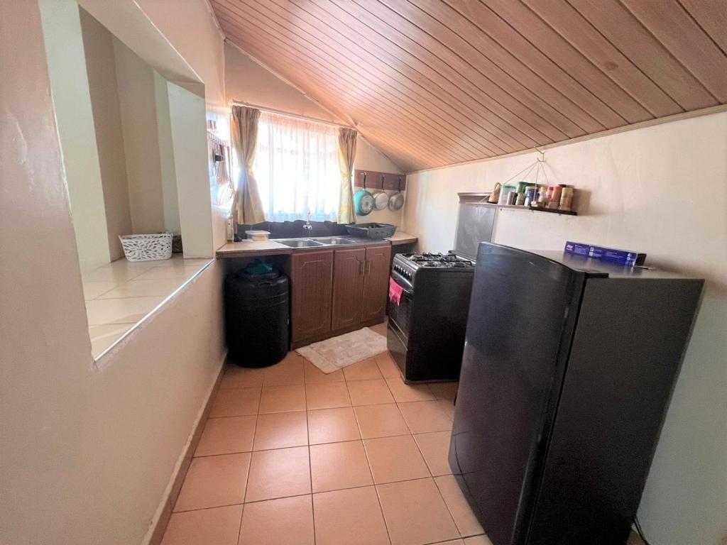 uma cozinha com um frigorífico preto e um balcão em Penthouse Studio Apartment em Nairobi
