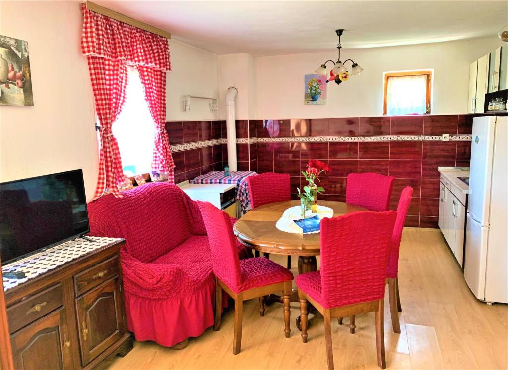 a kitchen with red chairs and a table and a kitchen with a tablektop at Home in Banja Luka- Vikendica za iznajmljivanje in Banja Luka