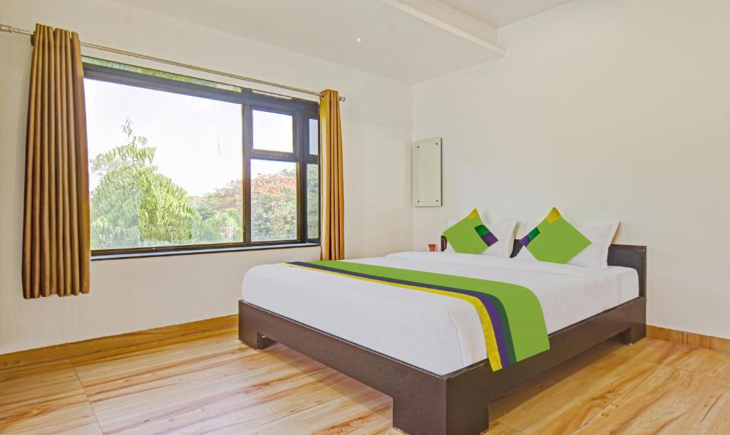 a bedroom with a bed and a large window at Treebo Trend Villa Inn Aurangabad in Aurangabad