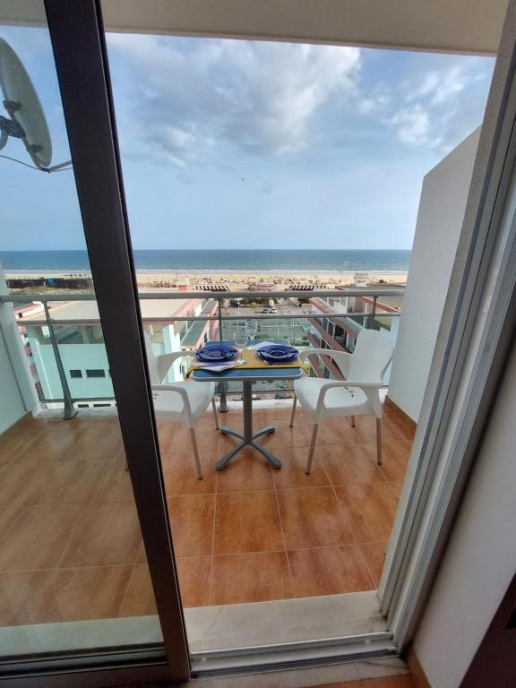 a balcony with a table and chairs and the ocean at À da Mamé - Monte Gordo in Monte Gordo