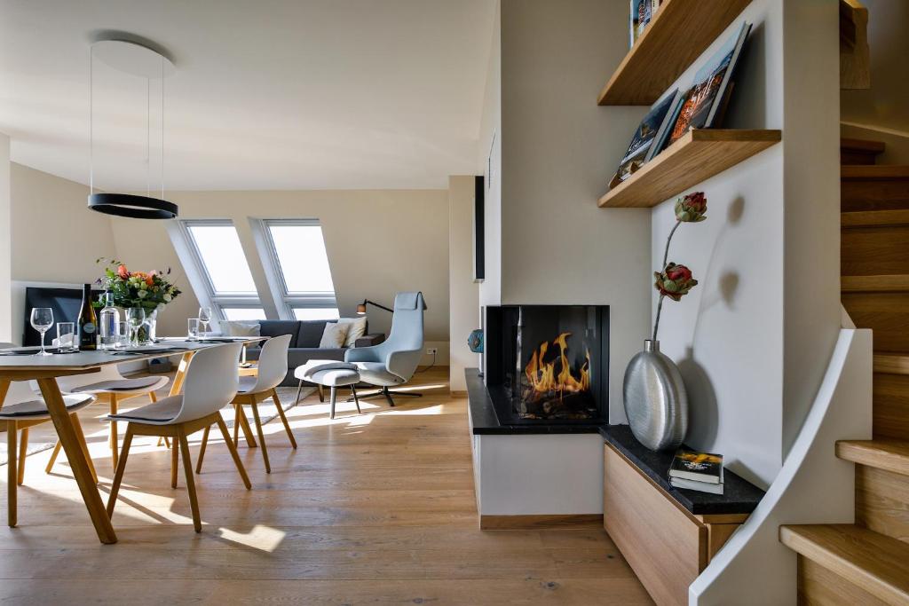 sala de estar con chimenea, mesa y sillas en Strandkieker, en Hörnum