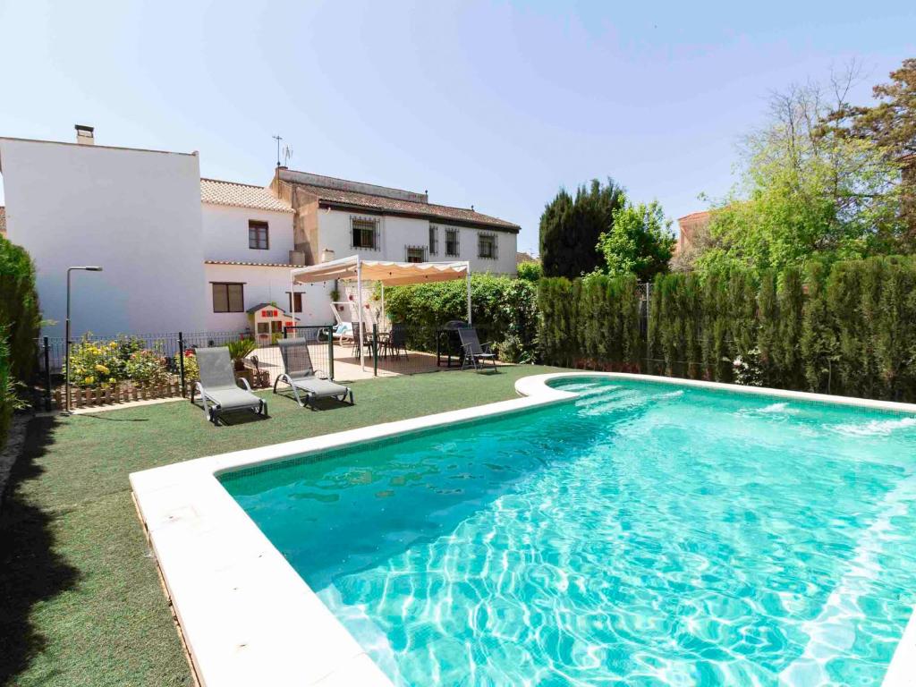 a swimming pool in a yard next to a house at Casa Valentina in Dúrcal