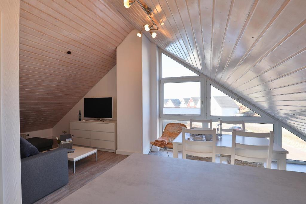 a living room with a large window and a table and chairs at Duenenblick in Hörnum