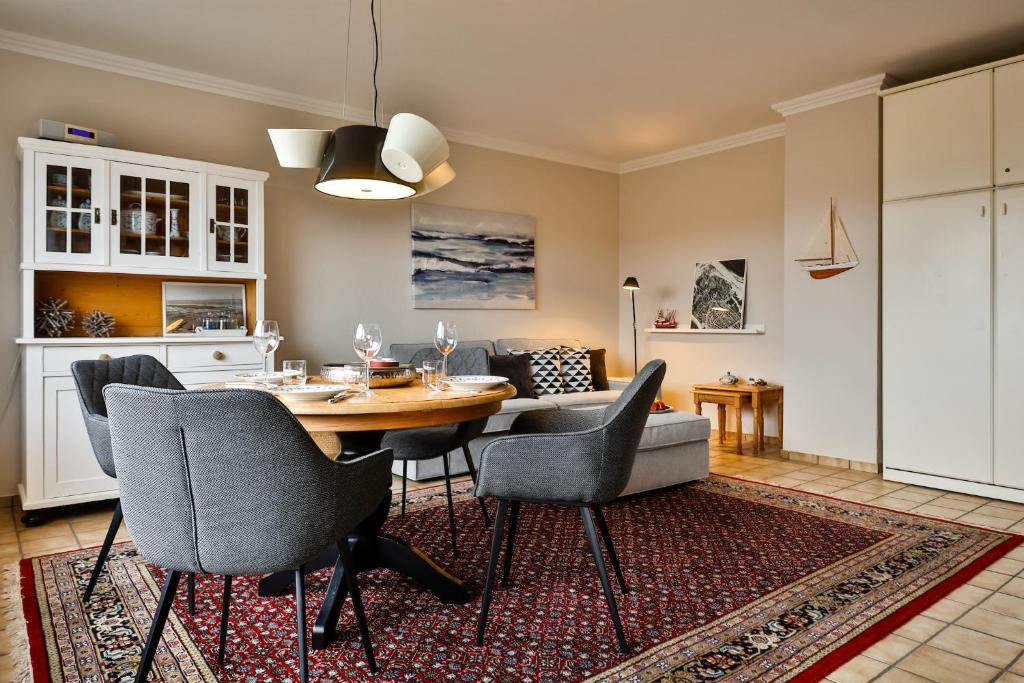 Un comedor y una sala de estar con mesa y sillas. en Buder Suite, en Hörnum