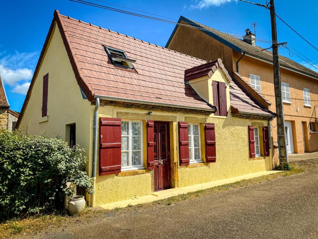 a yellow and red house with red doors on a street at la petite maison d'Albert in La Motte-Saint-Jean