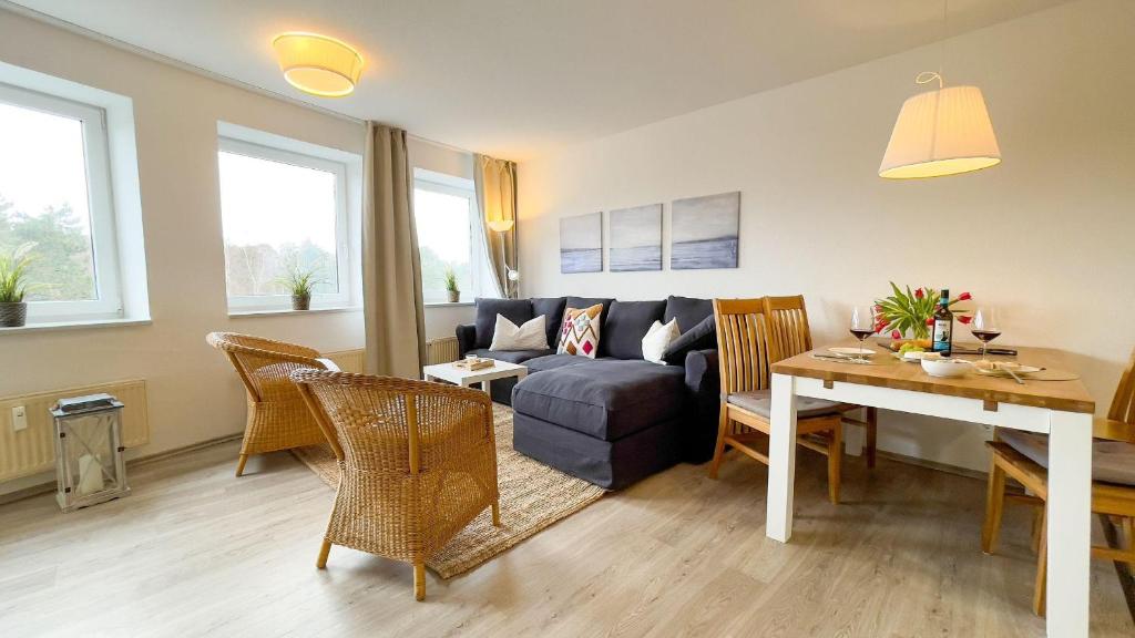 ein Wohnzimmer mit einem Sofa und einem Tisch in der Unterkunft Strandhaus Nordseebrandung Fewo A4.2 in Cuxhaven