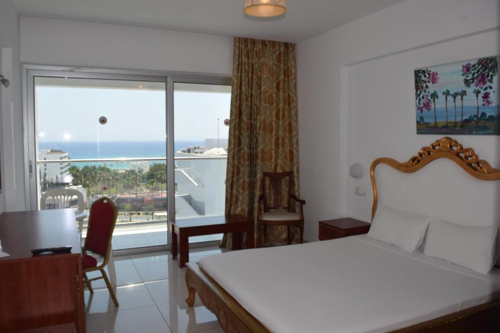 a bedroom with a bed and a view of the ocean at Corfu Hotel in Ayia Napa