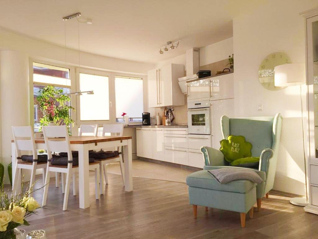 eine Küche und ein Esszimmer mit einem Tisch und Stühlen in der Unterkunft Strandhaus Nordseebrandung Fewo A2.5 in Cuxhaven