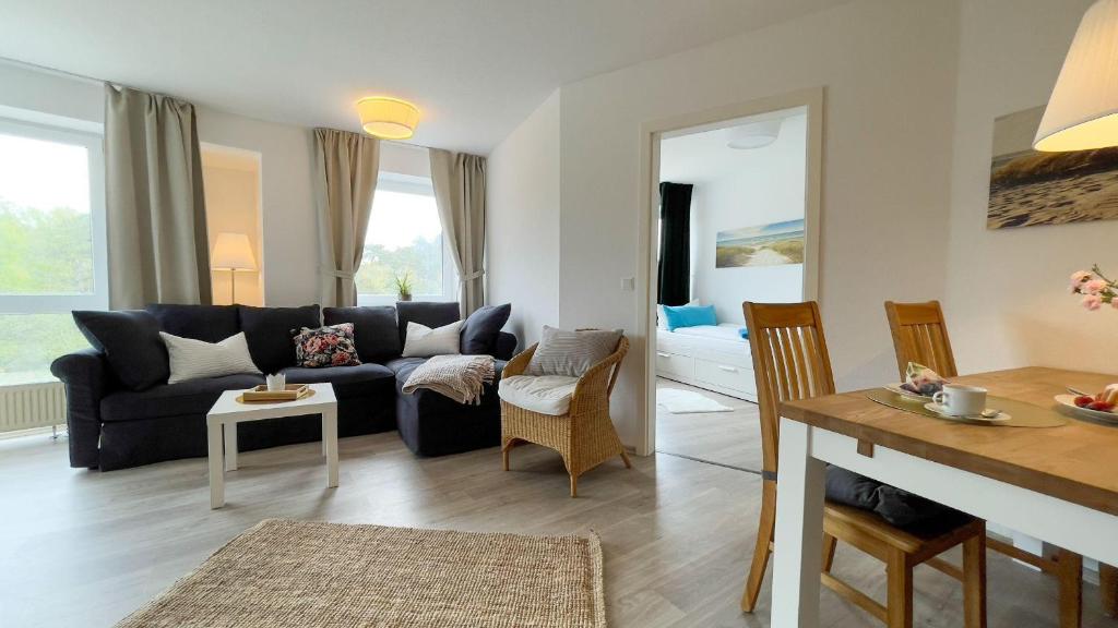 ein Wohnzimmer mit einem Sofa und einem Tisch in der Unterkunft Strandhaus Nordseebrandung Fewo A4.3 in Cuxhaven