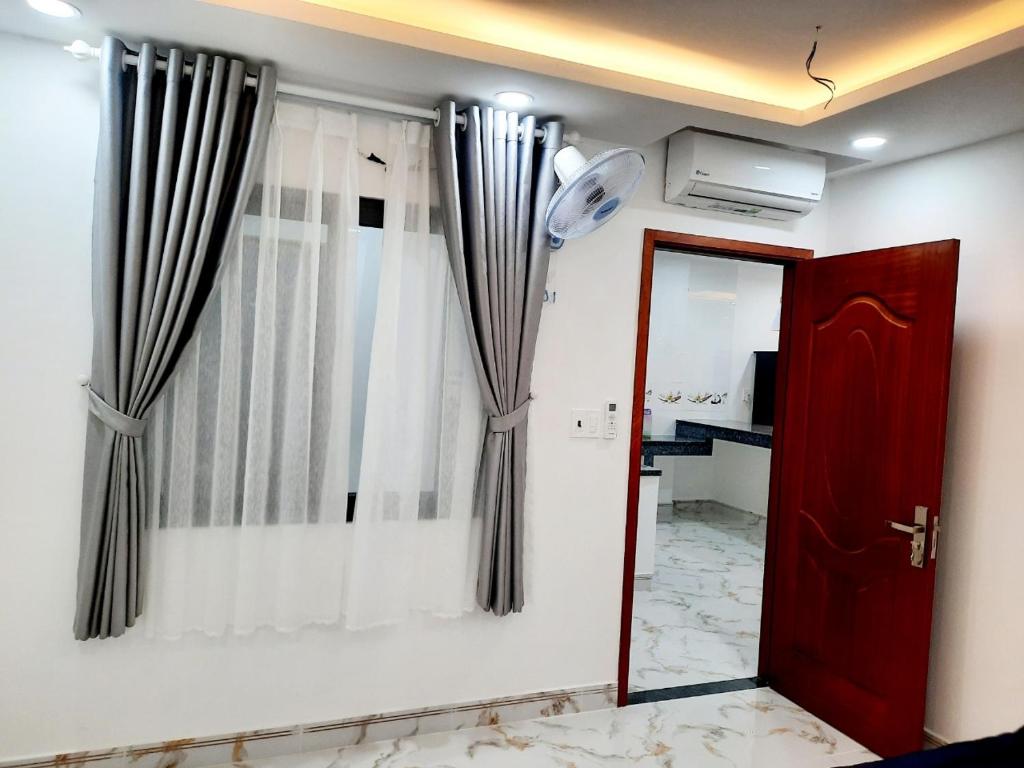 Zimmer mit roter Tür und Vorhängen in der Unterkunft MM's House in Ho-Chi-Minh-Stadt