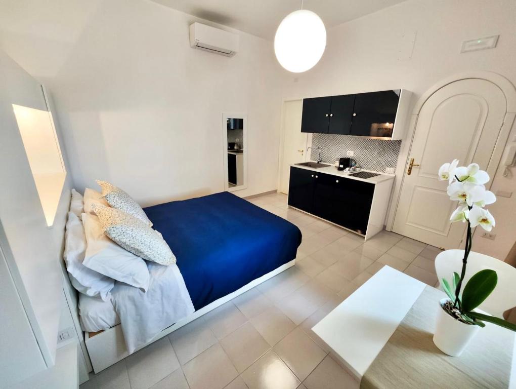 a bedroom with a blue bed and a kitchen at Residence Villa Giordano in Vietri