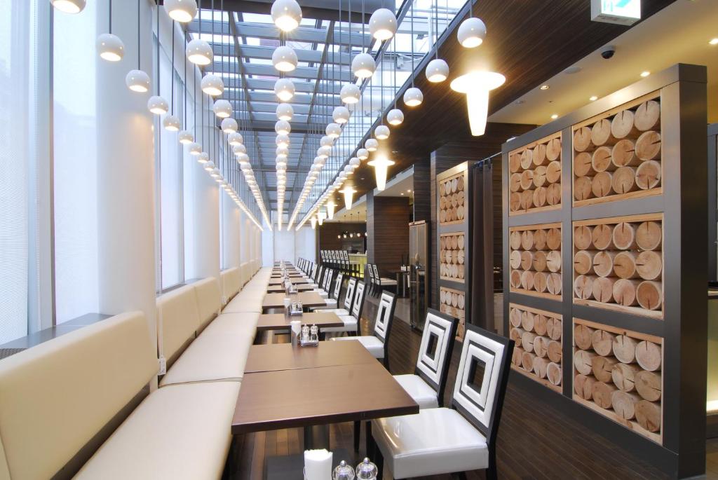 a dining room with tables and chairs and a wall of wine barrels at Citadines Central Shinjuku Tokyo in Tokyo
