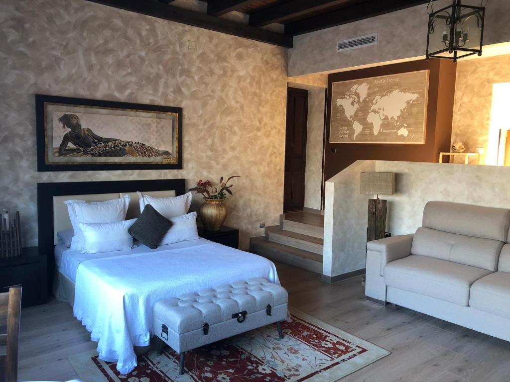 een slaapkamer met een bed, een bank en een stoel bij Cigarral los Segadores in Casarrubios del Monte