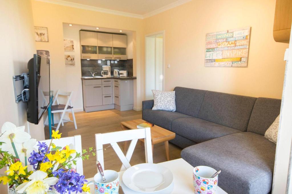 ein Wohnzimmer mit einem Sofa und einem Tisch in der Unterkunft Haus Frauenpreiss - Ferienwohnung 57 in Cuxhaven