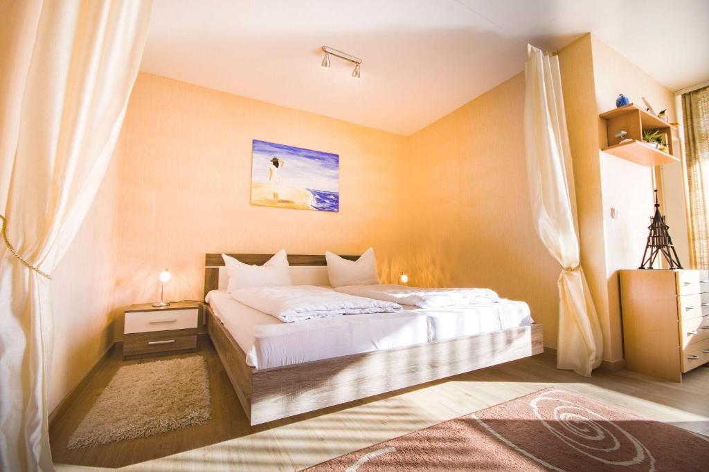 ein Schlafzimmer mit einem großen Bett mit weißer Bettwäsche in der Unterkunft Frauenpreis Whg. 205 in Cuxhaven