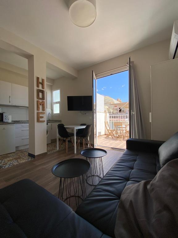 ein Wohnzimmer mit einer Couch und einem Tisch in der Unterkunft Apartamentos San Miguel in Torremolinos