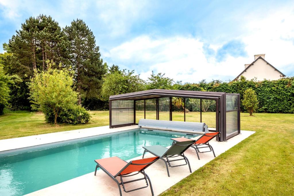 uma piscina com cadeiras e um gazebo em Green Lodge - Piscine chauffée et grand Jardin à proximité des Plages de Pléneuf Val-André em Saint-Alban