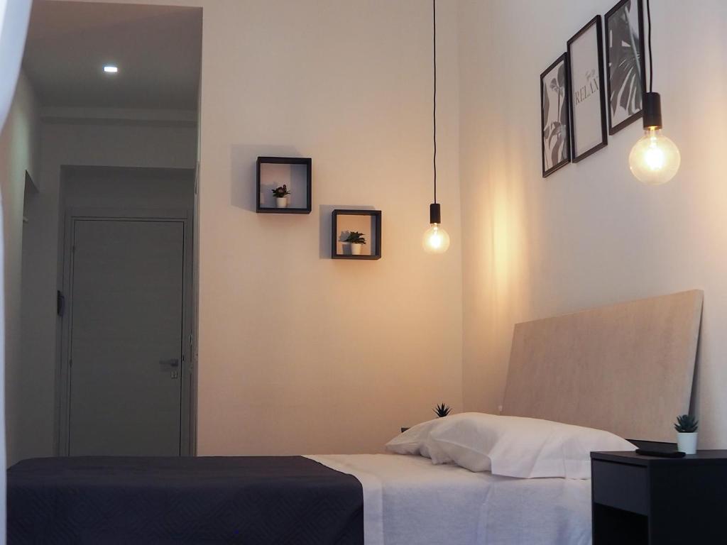 een slaapkamer met een bed en drie foto's aan de muur bij DonPè in Agrigento