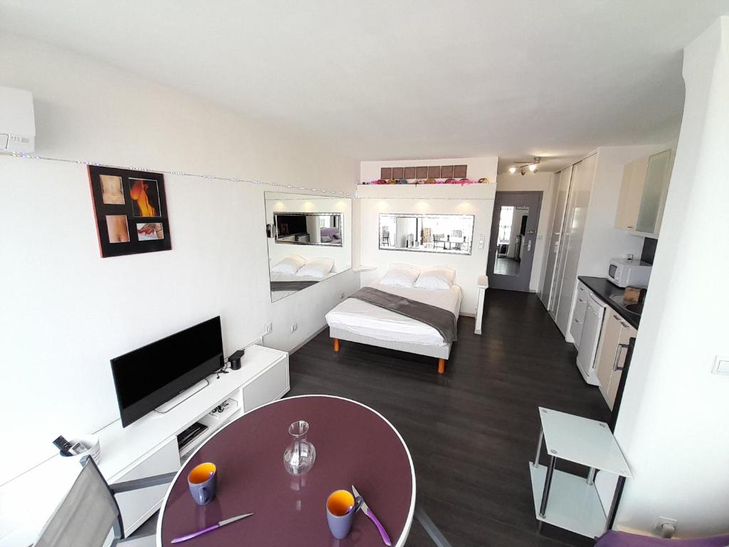 uma pequena sala de estar com um sofá e uma mesa em Studio Village Naturiste Résille em Cap d'Agde