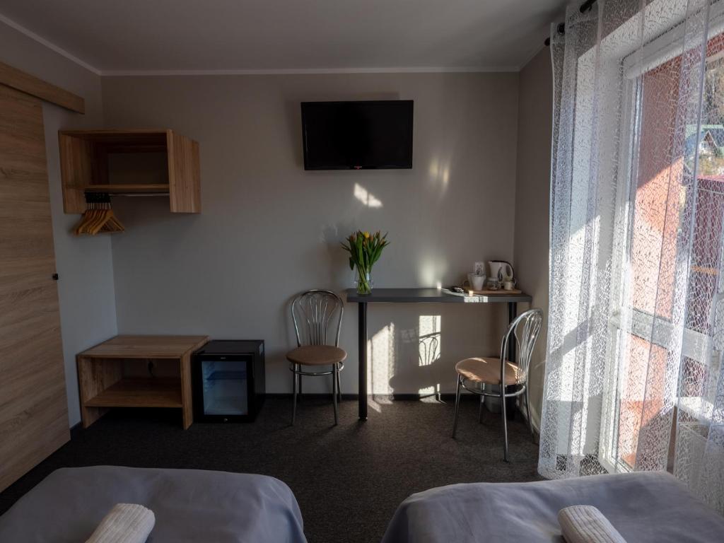 Zimmer mit einem Bett und einem Tisch mit Stühlen in der Unterkunft Ada in Muszyna