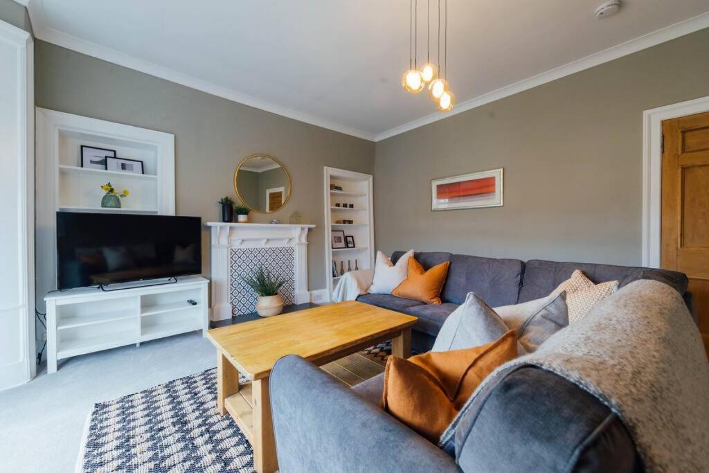 a living room with a couch and a tv at The Riverside Apartment (free parking) in Stirling