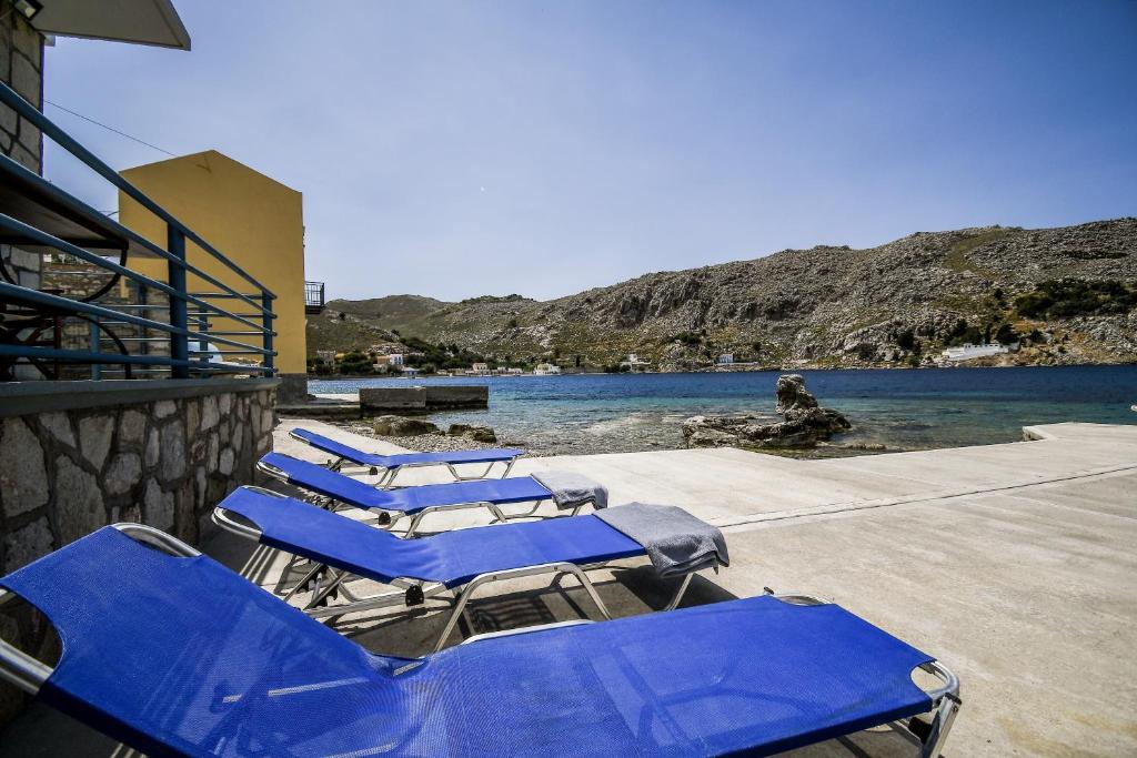 a group of blue lounge chairs on a beach at Ponente in Symi