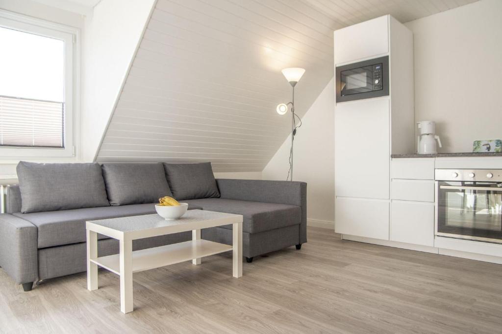 salon z kanapą i stołem w obiekcie Ferienwohnung-Haus-Ingeborg-Wohnung-3-OG w mieście Cuxhaven