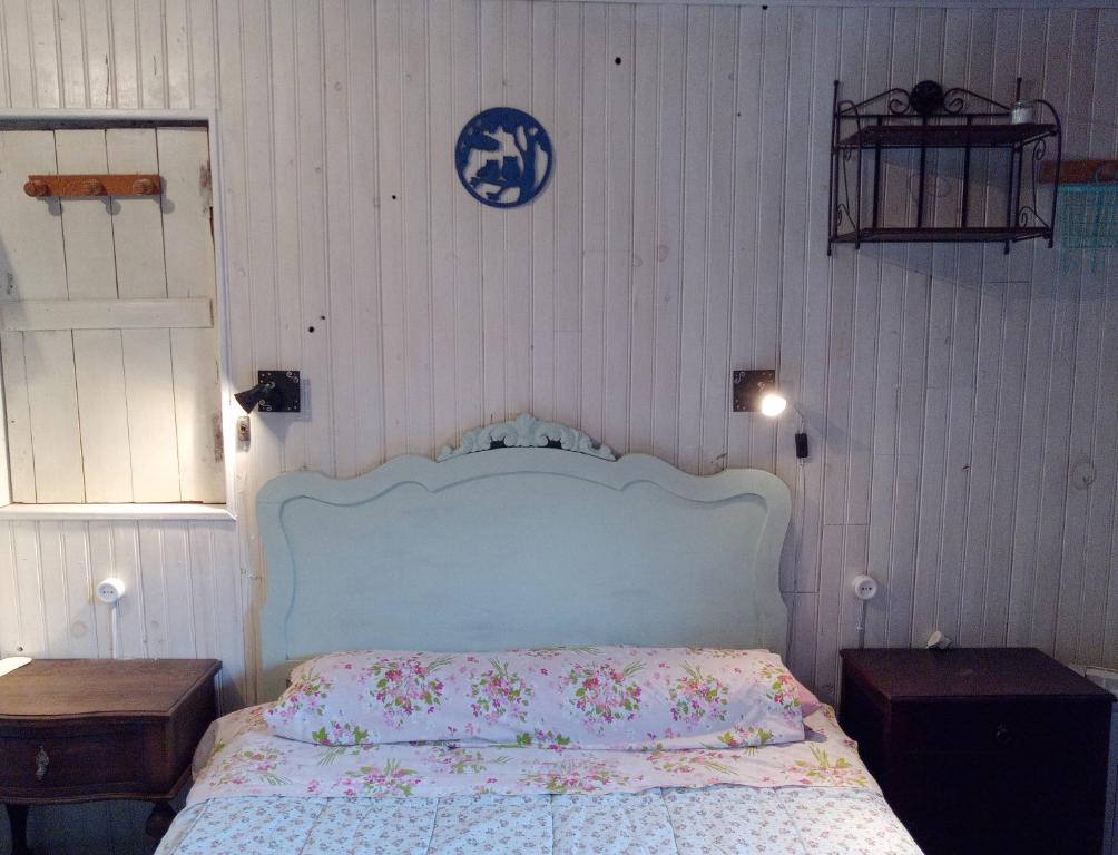 Cabaña del Zapatero El Bierzo Ponferrada في Valdecañada: غرفة نوم مع سرير بلوحة راس زرقاء