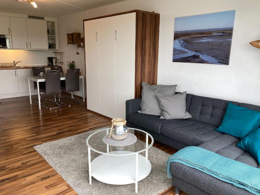 uma sala de estar com um sofá e uma mesa em Frische-Brise-06-04 em Cuxhaven