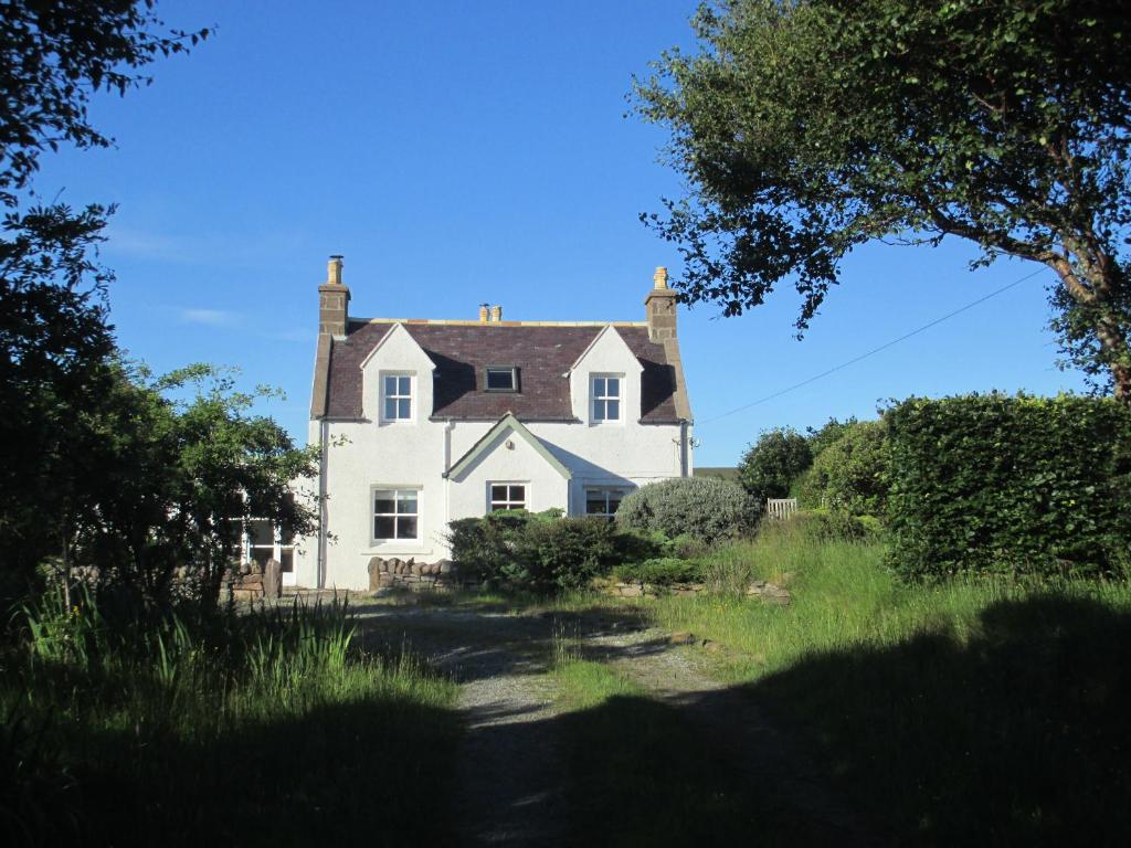 a large white house in the middle of a field at The Loan in Achiltibuie