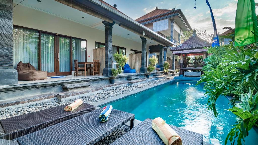 uma imagem de uma villa com piscina em The Village Guest House em Ubud