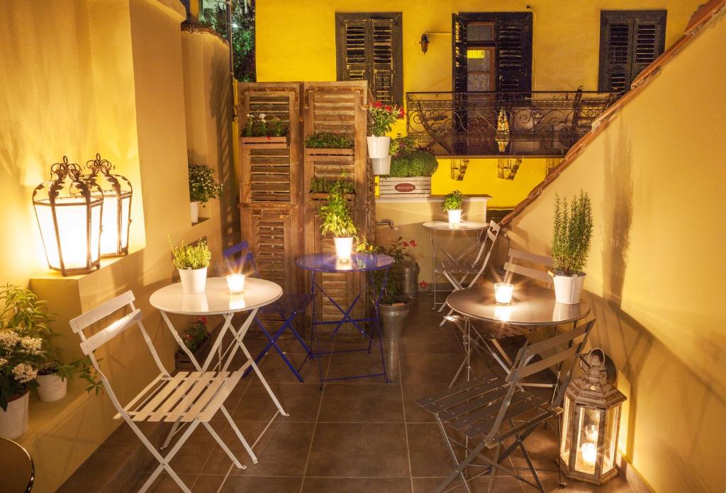 patio ze stołami i krzesłami oraz balkonem w obiekcie Nafplion 1841 w Nauplionie