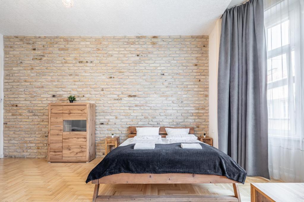 ブダペストにあるCentral Luxury Apartment with ACのレンガの壁、ベッド付きのベッドルーム1室