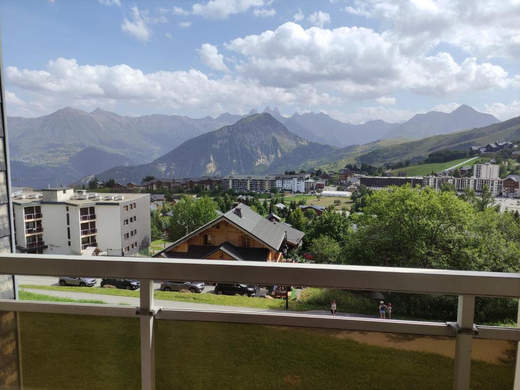 Elle comprend un balcon offrant une vue sur la ville et les montagnes. dans l'établissement Appartement La Toussuire avec vue exceptionnelle, à La Toussuire