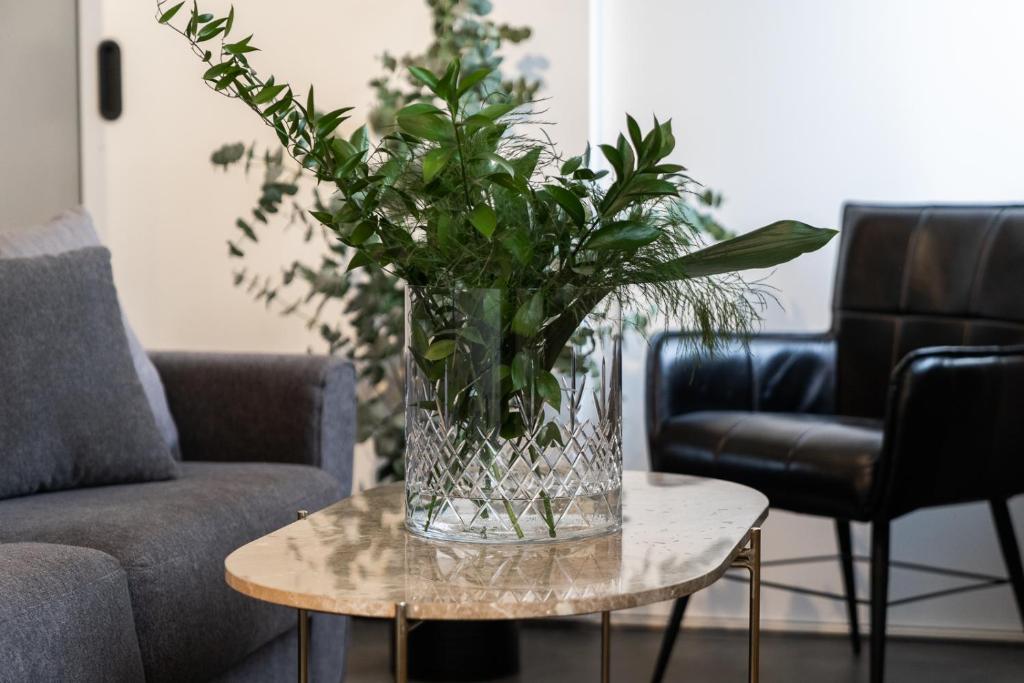 un jarrón de flores sobre una mesa en la sala de estar en Keflavik Luxury apartment - KLA, en Keflavík