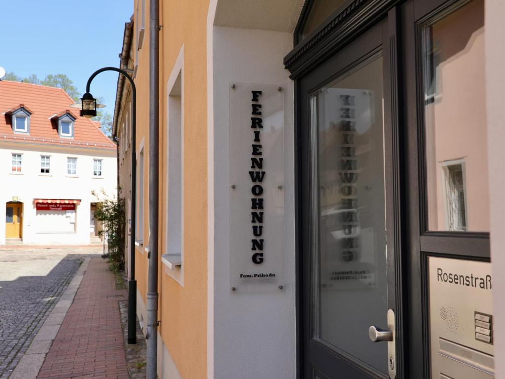 een bord aan de zijkant van een gebouw naast een deur bij Ferienwohnungen Prihoda in Wilsdruff