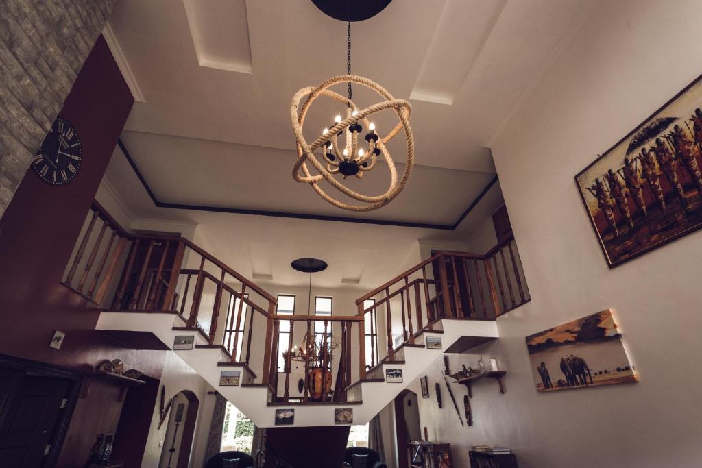 una scala con un lampadario a braccio in una stanza di Room in BB - Kilihouse Bb Large Ensuite Double Bedroom a Thika