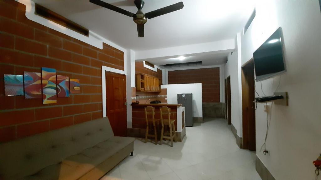 a living room with a ceiling fan and a brick wall at Cabañas Mar Caribe in Necoclí