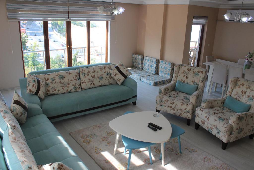 a living room with a couch and chairs and a table at FENDE DOLG SUITE APARTMENTS in Cimenli