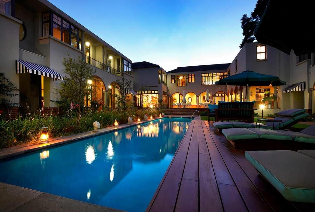Johannesburg的住宿－溫斯頓酒店，一座带躺椅的游泳池和一座建筑