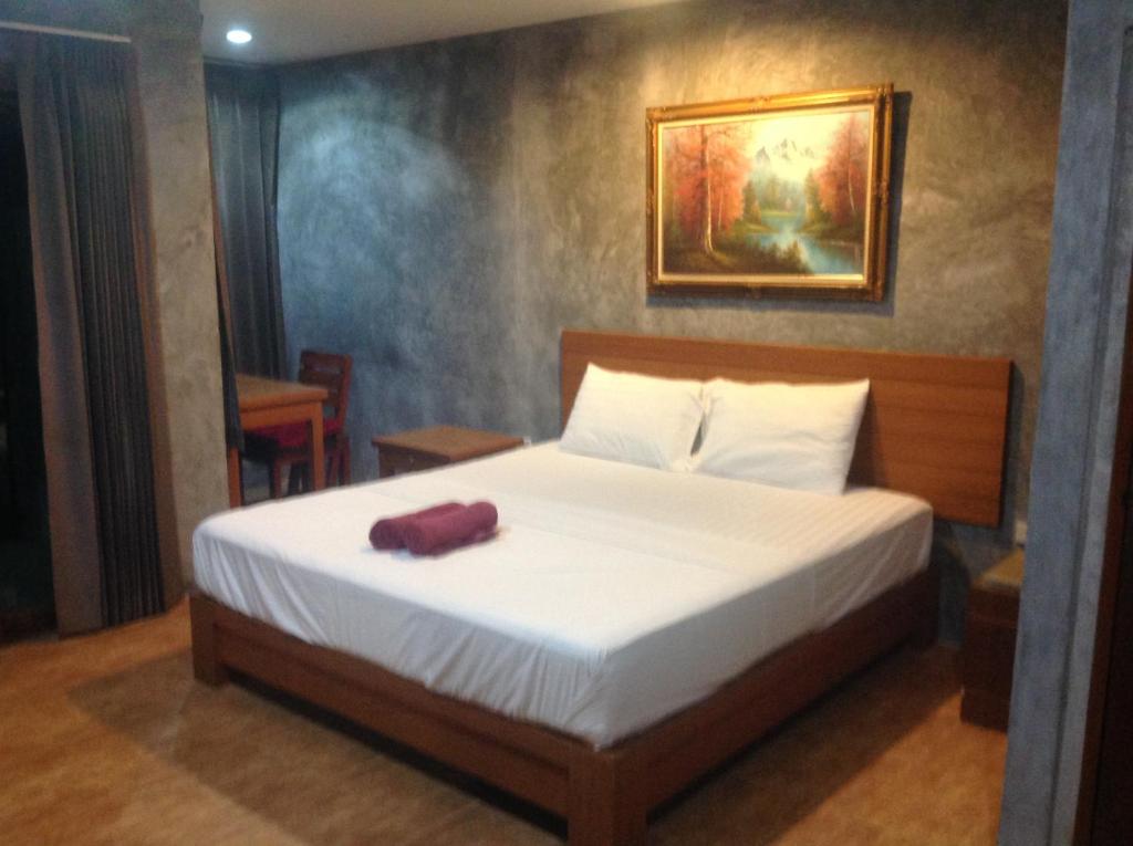 una camera da letto con un letto e un asciugamano rosso sopra di Waikiki Beach Garden Resort a Ban Nua